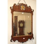 An 18th century walnut and parcel gilt wall mirror, the frame of shaped outline, with pierced