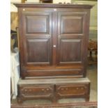 An antique oak wardrobe, the cornice above a pair of fielded panelled doors, the base fitted with