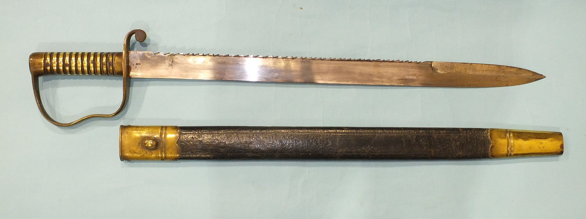 A British Pioneer sword with brass hilt and saw backed blade, 57cm, marked with crown over B21 and