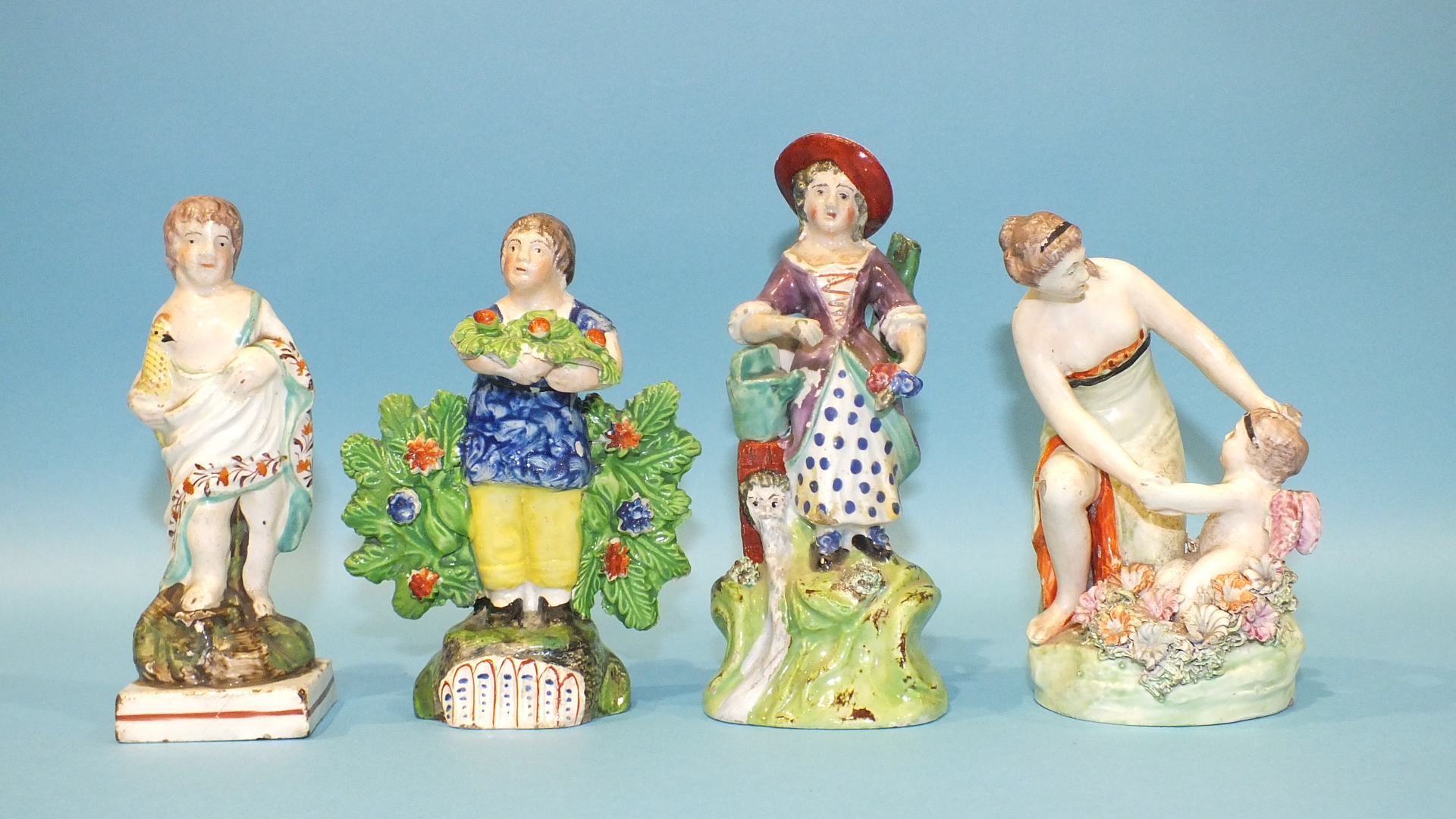 Four 19th century Staffordshire pearlware small figures, three representing children in rural