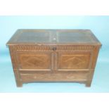 A 17th century oak panelled coffer, the hinged lid above bullet-moulded and carved frame inlaid