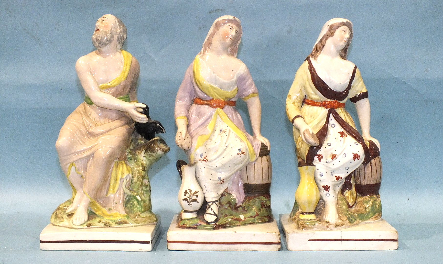 A pair of early-19th century Staffordshire pearlware square-based figures of Elijah and the widow