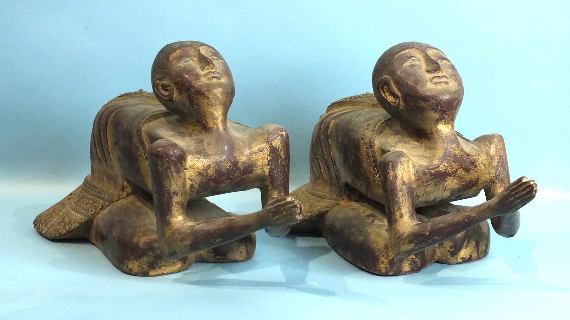 A pair of Burmese carved wood figures at prayer, 50cm long, 26cm high.