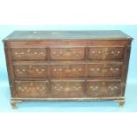 A Georgian oak and mahogany-banded chest of three small, one long and three false drawers below a