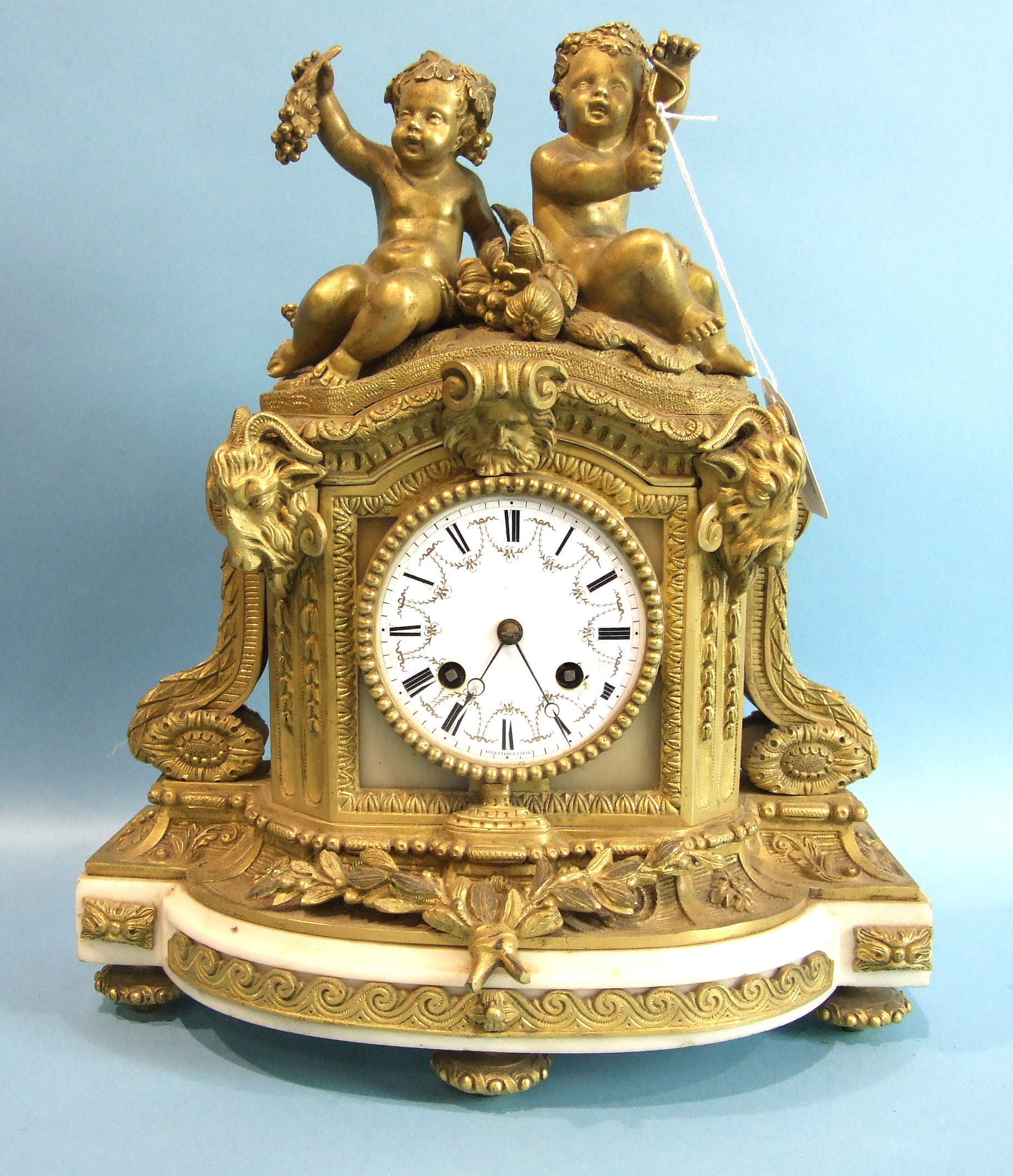 A 19th century French ormolu and alabaster mantel clock, the arched case surmounted by two