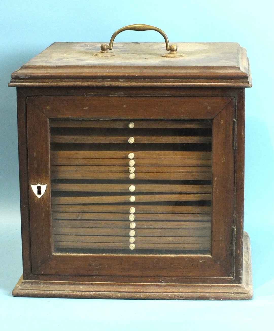 A 19th century walnut coin or collector's chest, having brass carrying handle and glazed door