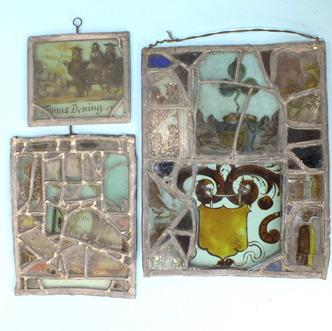 Fragments of 17th and 18th century stained glass windows later mounted in leaded panels, one bearing