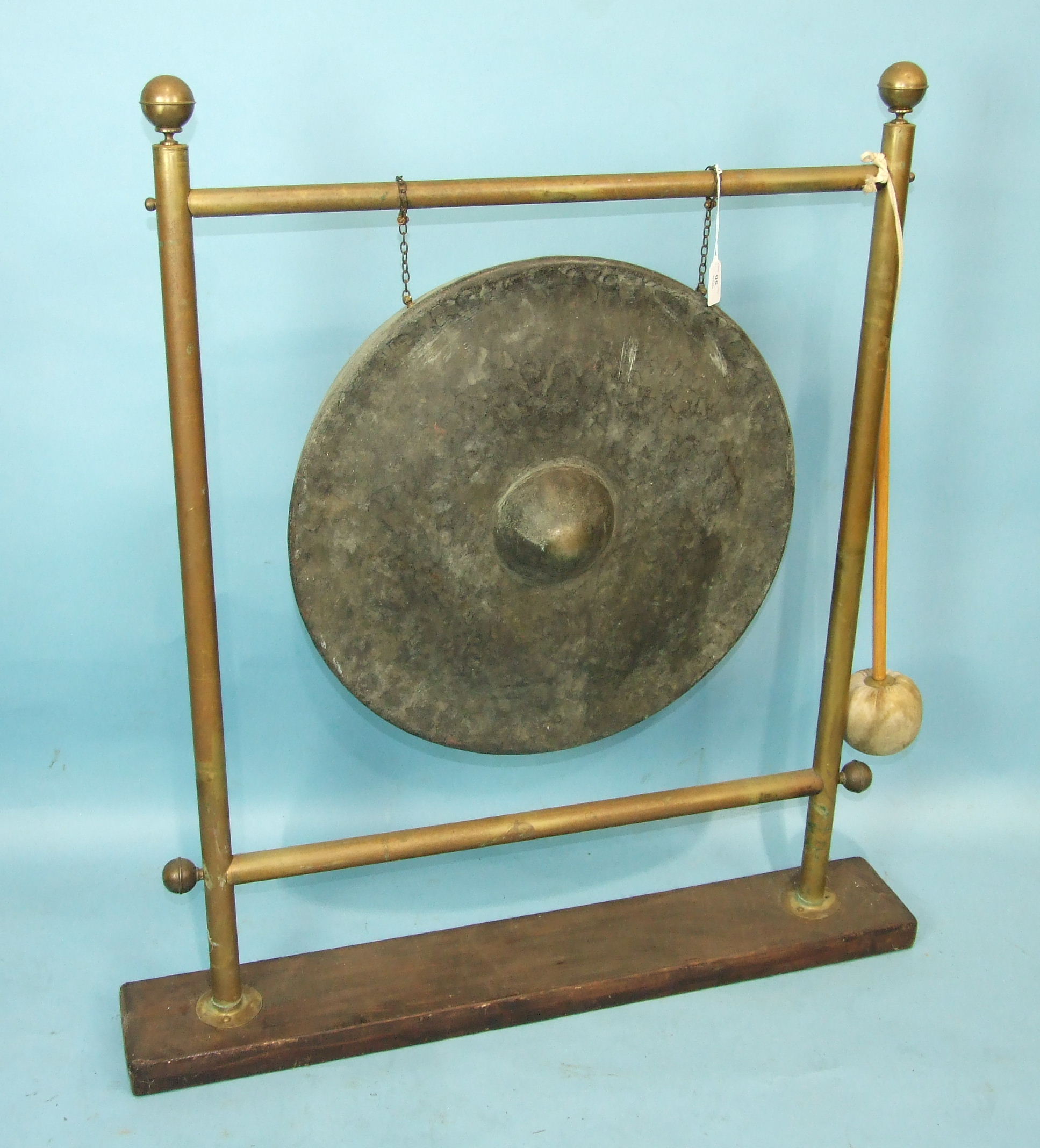 A circular bronze gong with central raised boss on later brass stand with beater, gong 55cm