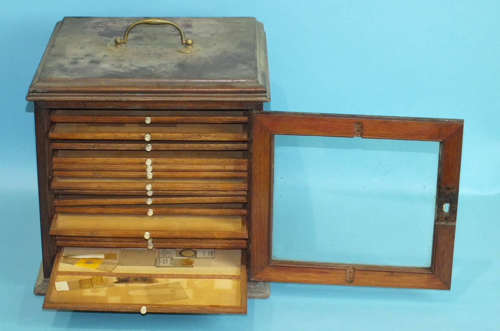 A 19th century walnut coin or collector's chest, having brass carrying handle and glazed door - Image 2 of 2