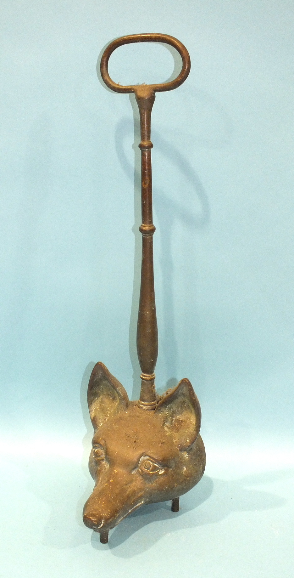 A brass fox mask door-stop with long handle, 48cm high.