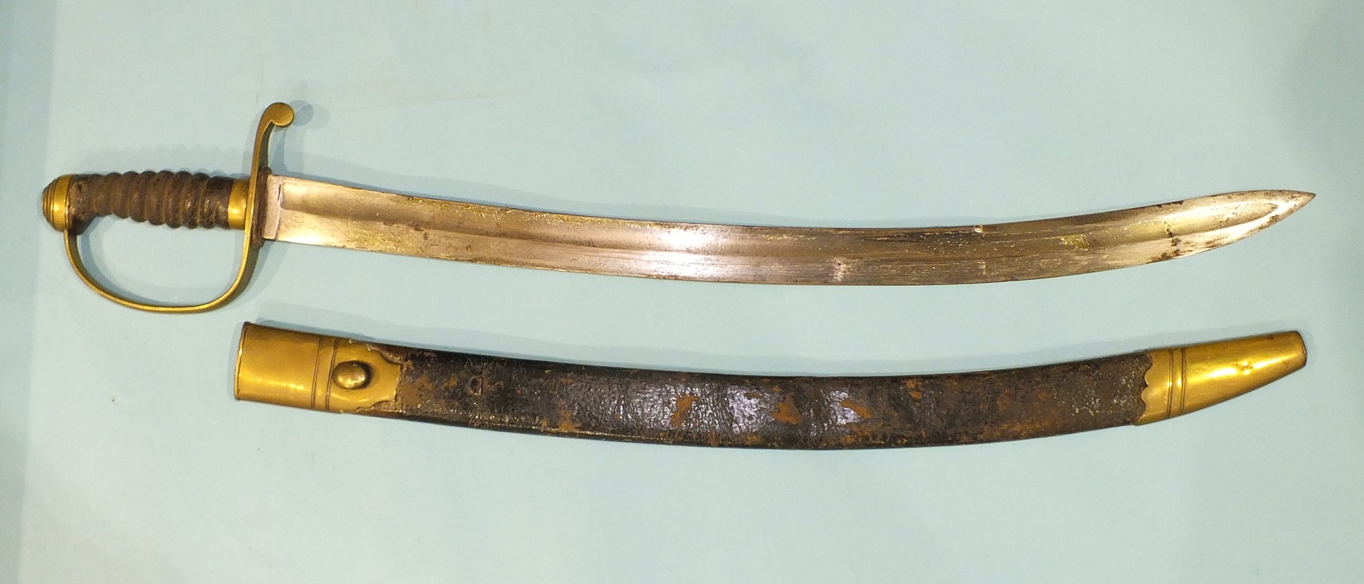 A brass stirrup hilted short sabre with fish-skin grip and 61cm slightly curved blade in brass