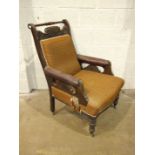 A late Victorian carved walnut salon chair with upholstered back, seat and arm pads, on turned