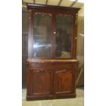 A Victorian mahogany bookcase, the cornice above a pair of glazed doors, a drawer and cupboard