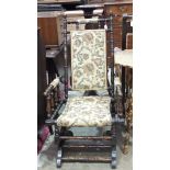 A stained and turned wood American style rocking chair with floral padded back and seat.