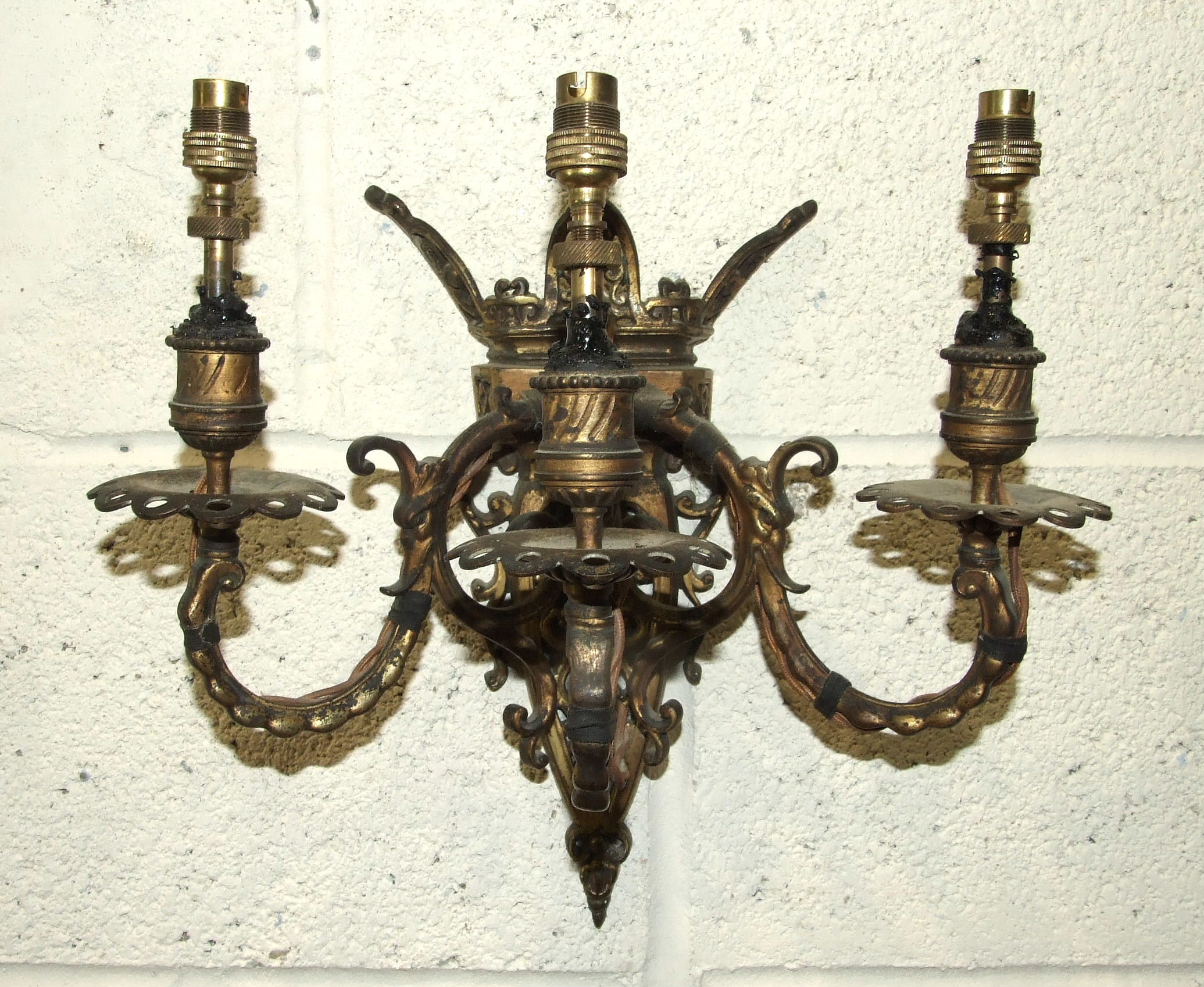 A pair of 19th century French gilt brass wall-mounted candelabra, each with three branches,