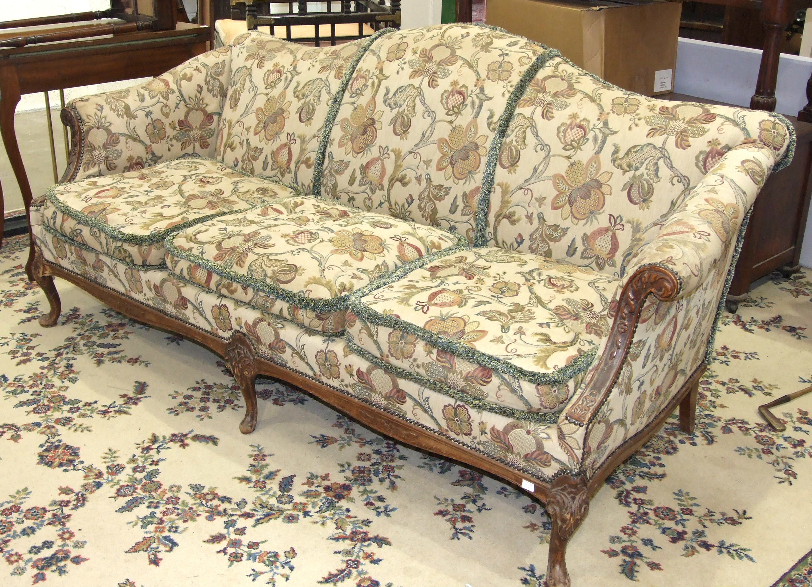 A walnut-framed three-seat sofa raised on short carved cabriole legs, 213cm wide.