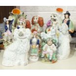 A collection of Staffordshire flat-back figures and Staffordshire spaniels, (some restoration and