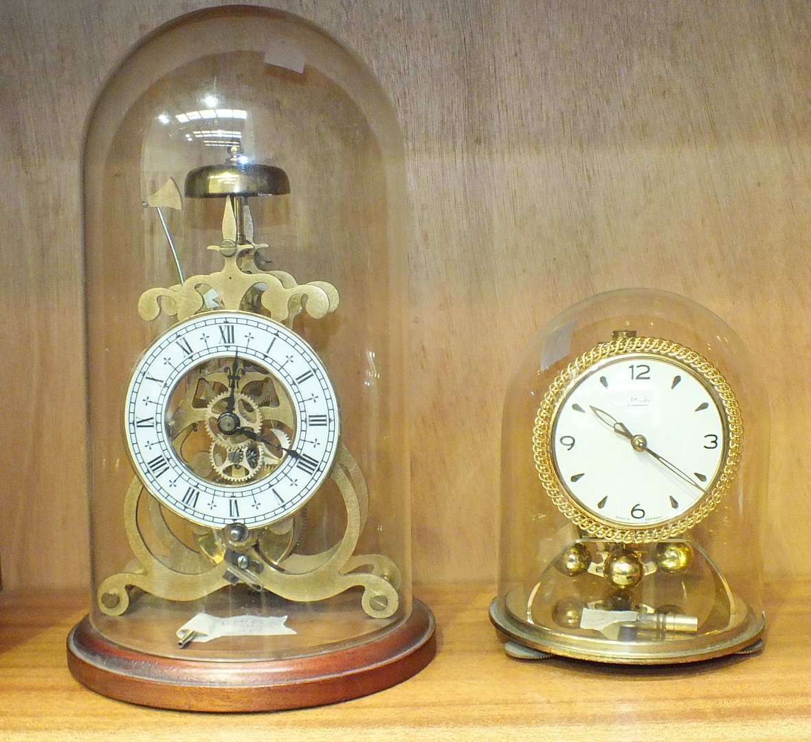 A reproduction skeleton timepiece with white dial, under glass dome, 28cm high and a 20th century