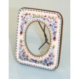 A miniature glass mosaic picture frame decorated with blue and white flowers around an oval