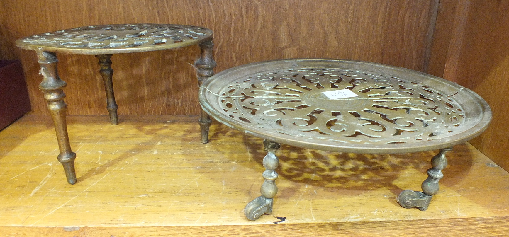 An unusual brass coaster, the circular extending pierced top on short turned legs with castors, 23cm