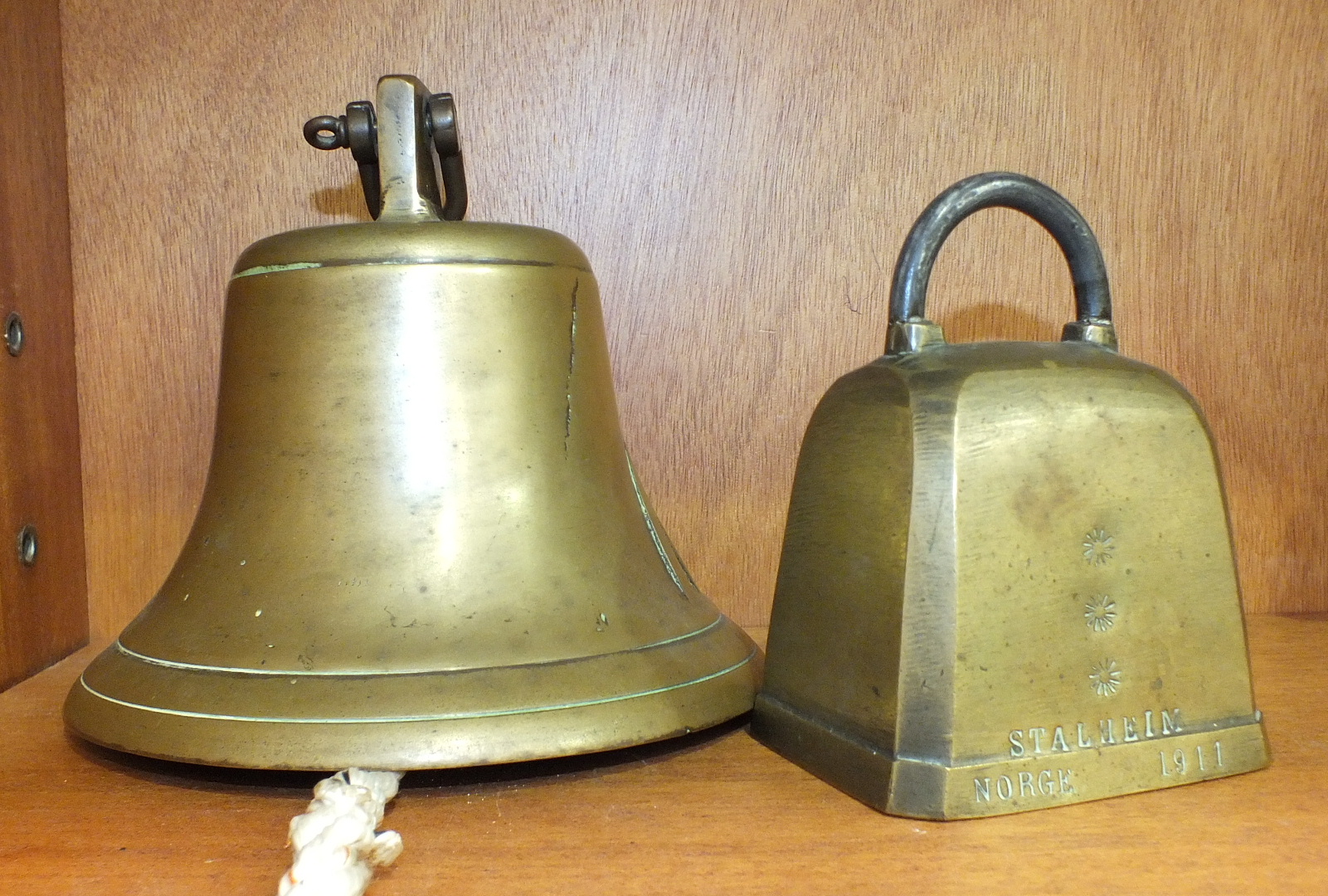 A bronze bell with iron clapper, cast with military bronzed arrow, 14cm high and a Norwegian