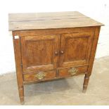 An antique oak pot cupboard having a pair of panelled doors and two small drawers, 70cm wide, 70cm