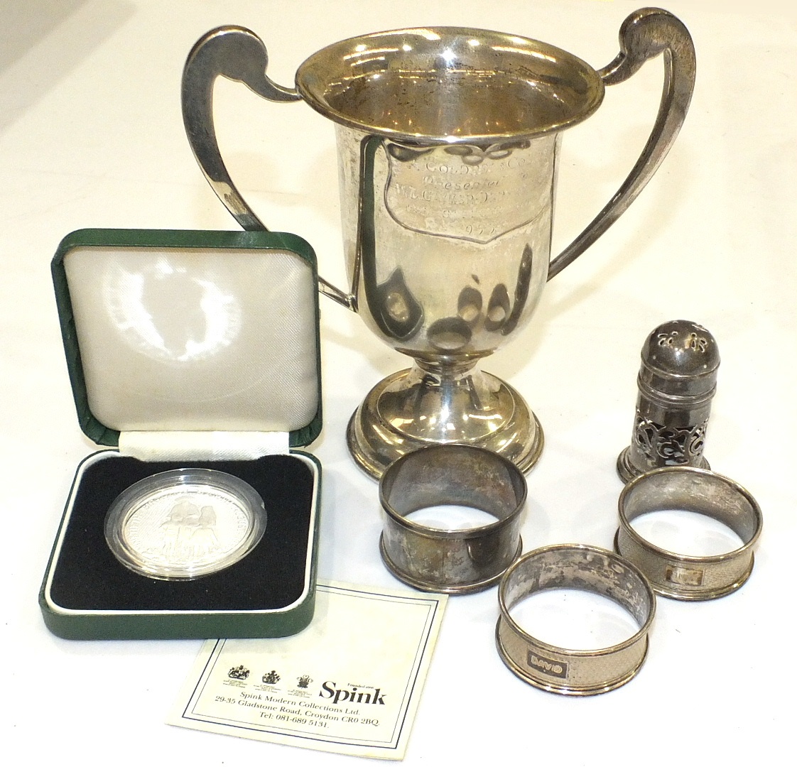 A small silver two-handled trophy cup, marks rubbed and two silver napkin rings, (3).