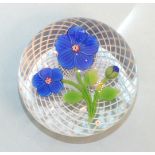 A modern limited-edition Baccarat glass paperweight decorated with deep blue flowers, etched '38/