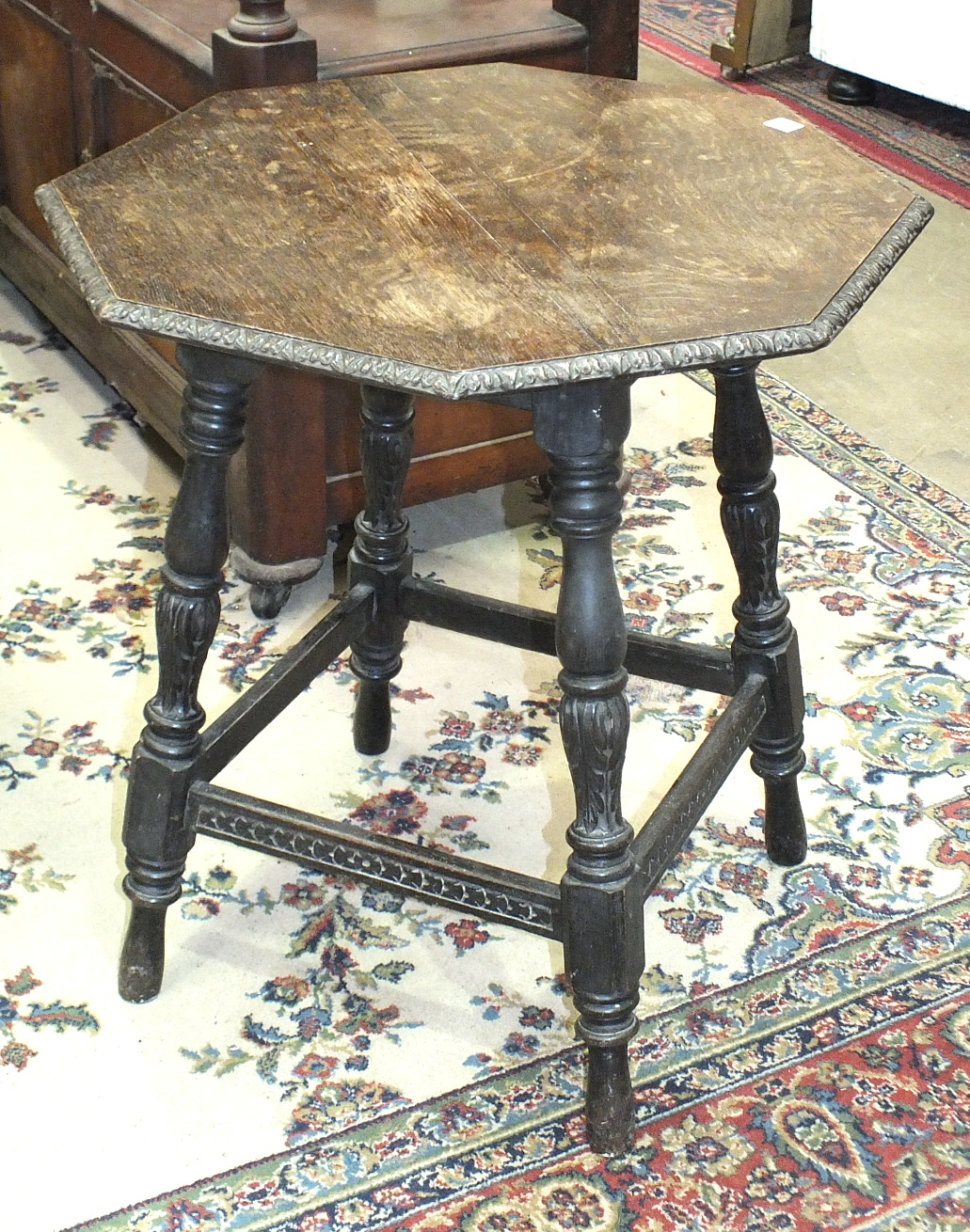 A 20th century oak octagonal occasional table on turned legs and a brass pierced fire kerb, (2).