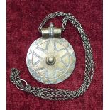 An Eastern white metal amulet incised with script to one side, 9cm, suspended from a chain.