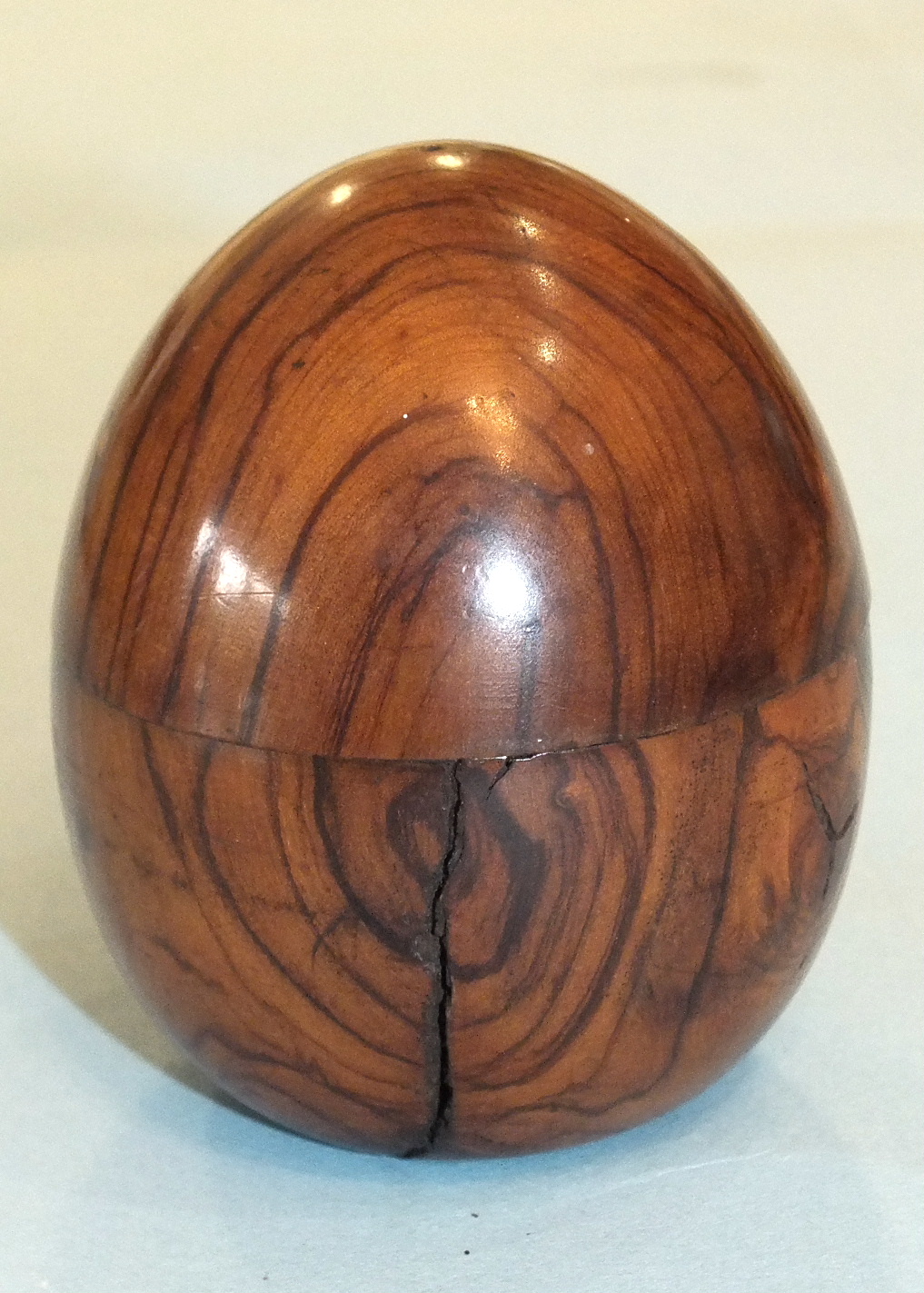 An olive wood egg-shaped travelling inkwell, the screw top over a glass bottle, 6.5cm high. - Image 2 of 2