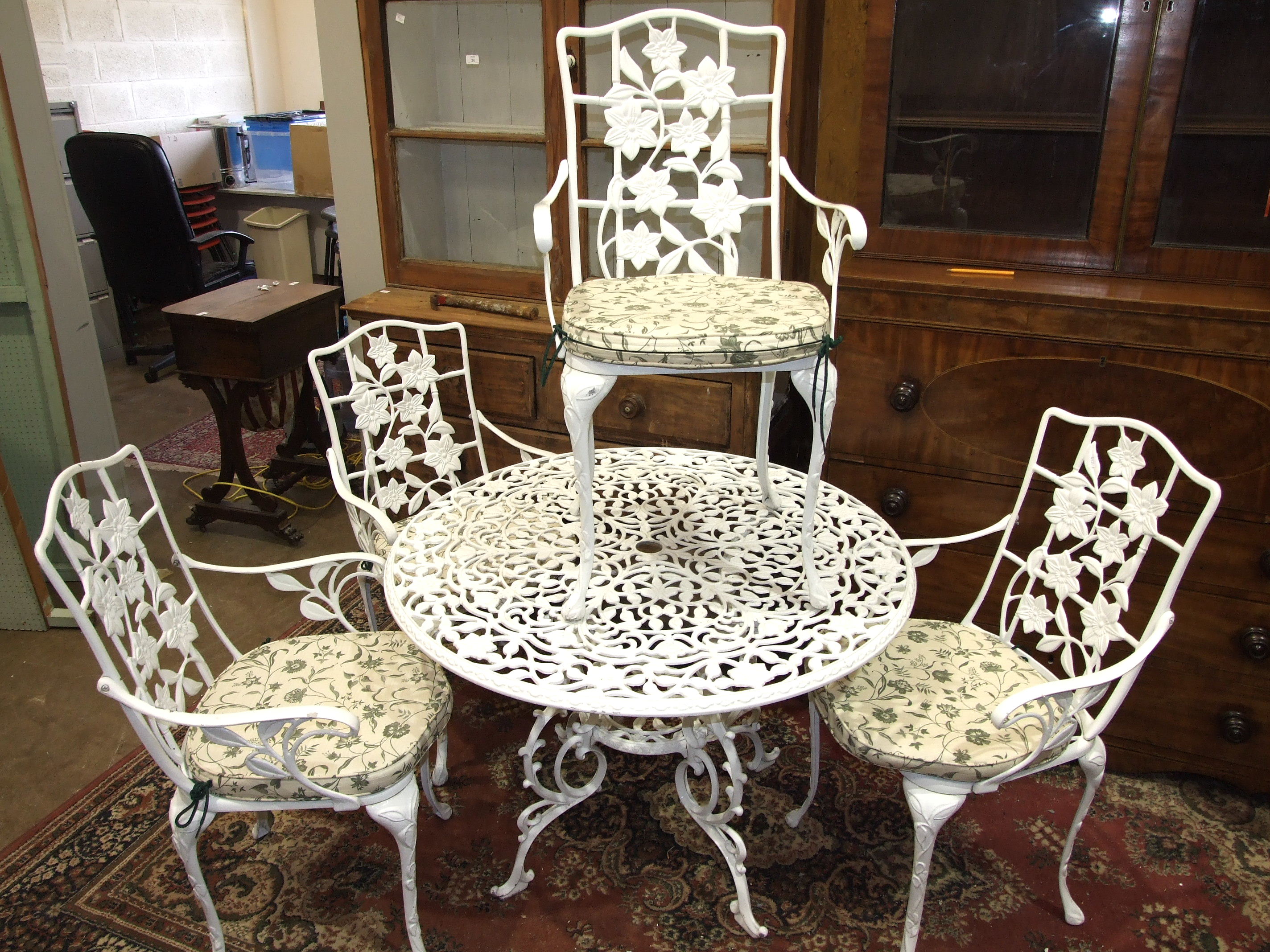 A modern white-painted aluminium garden table and four chairs, table 102cm diameter.