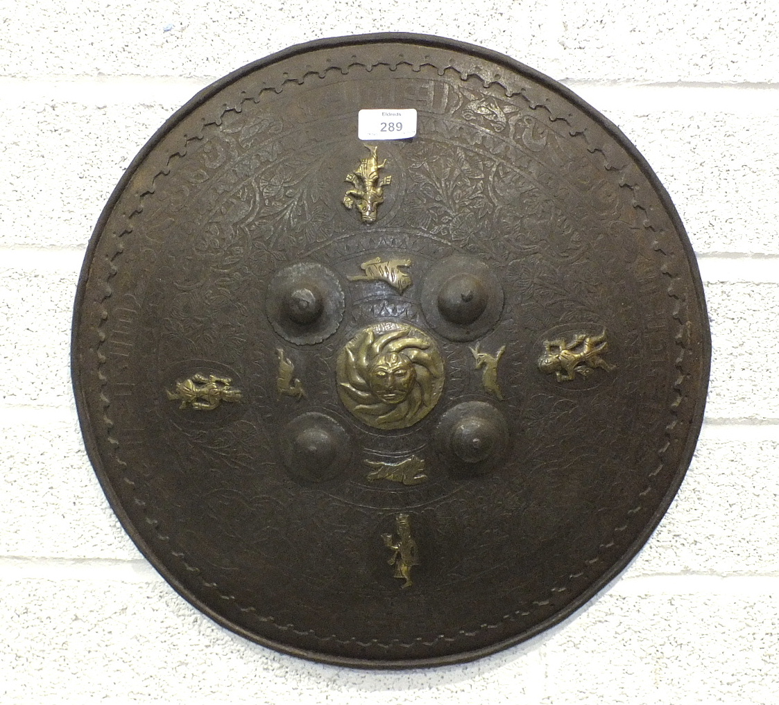 An Asian metal shield applied with brass animals and figures, 44cm diameter.