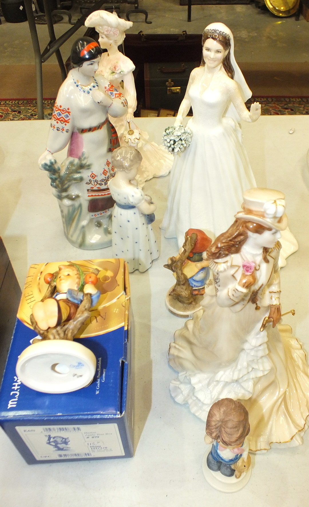 Two Hummel figures, two Coalport figurines, a Royal Copenhagen figure of a young girl carrying a