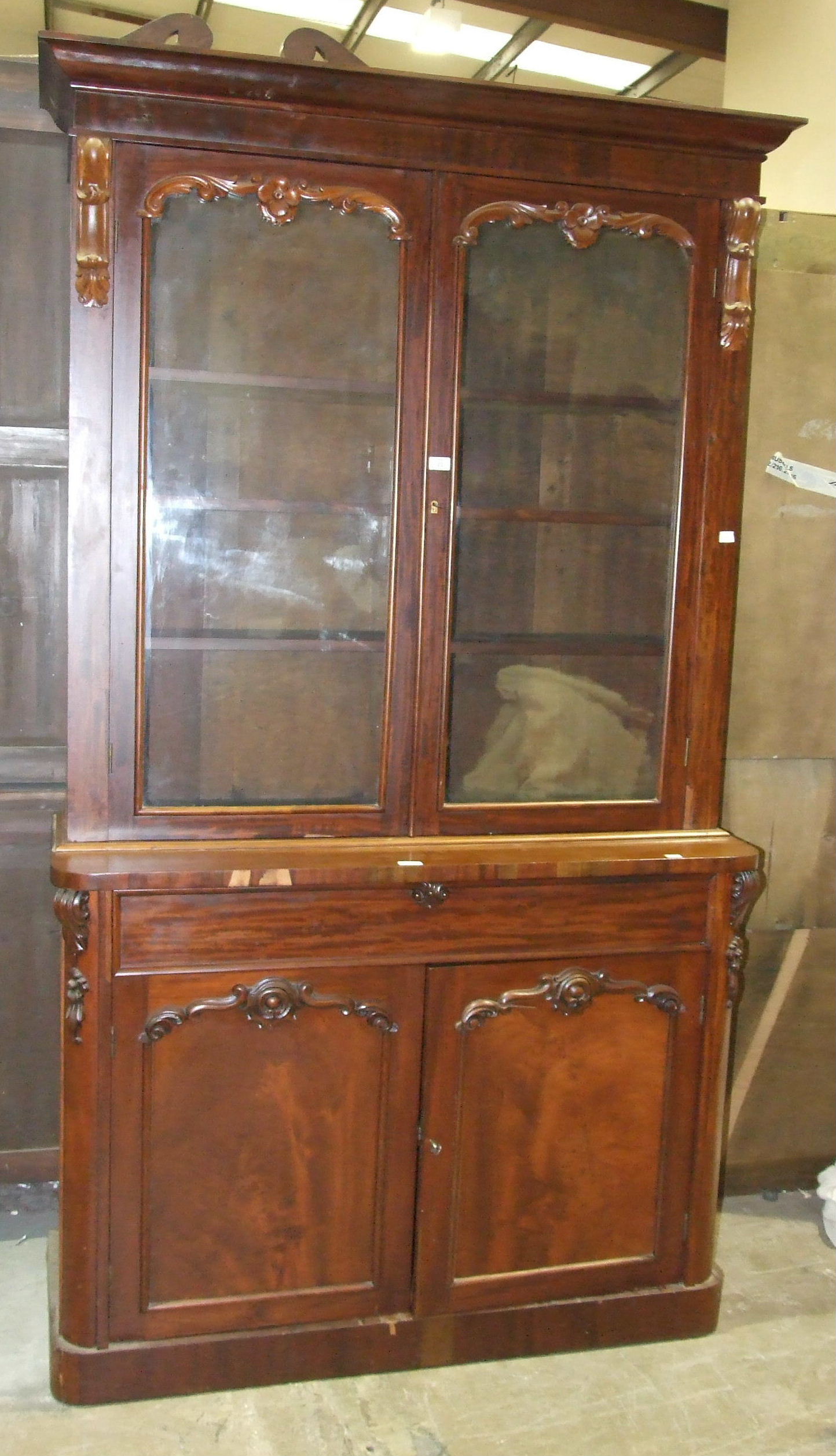 A Victorian mahogany bookcase, the cornice above a pair of glazed doors, a drawer and cupboard
