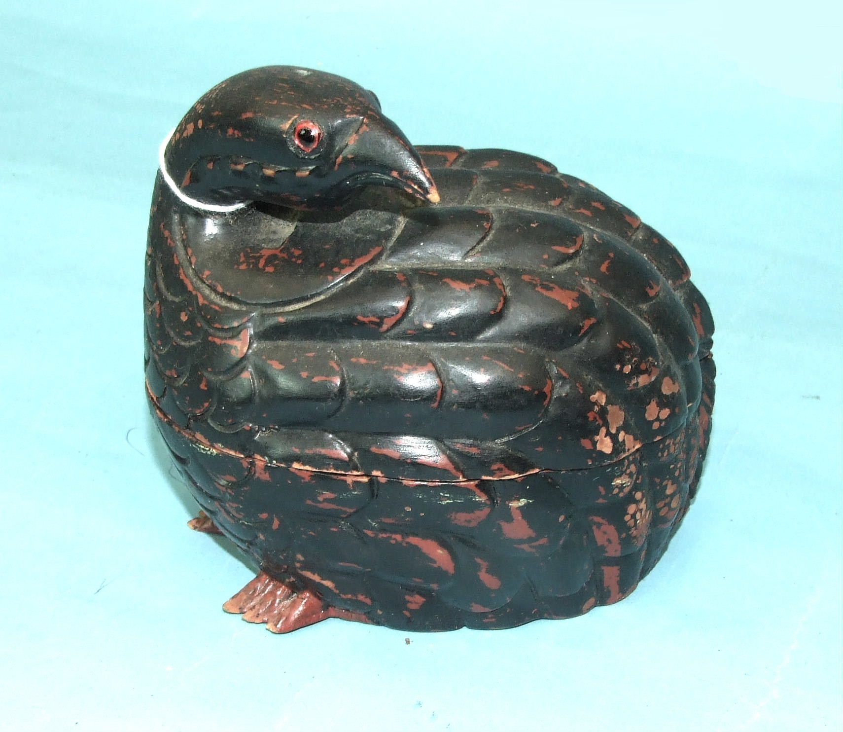 A lacquered wood box and cover in the form of a quail, 15cm high.