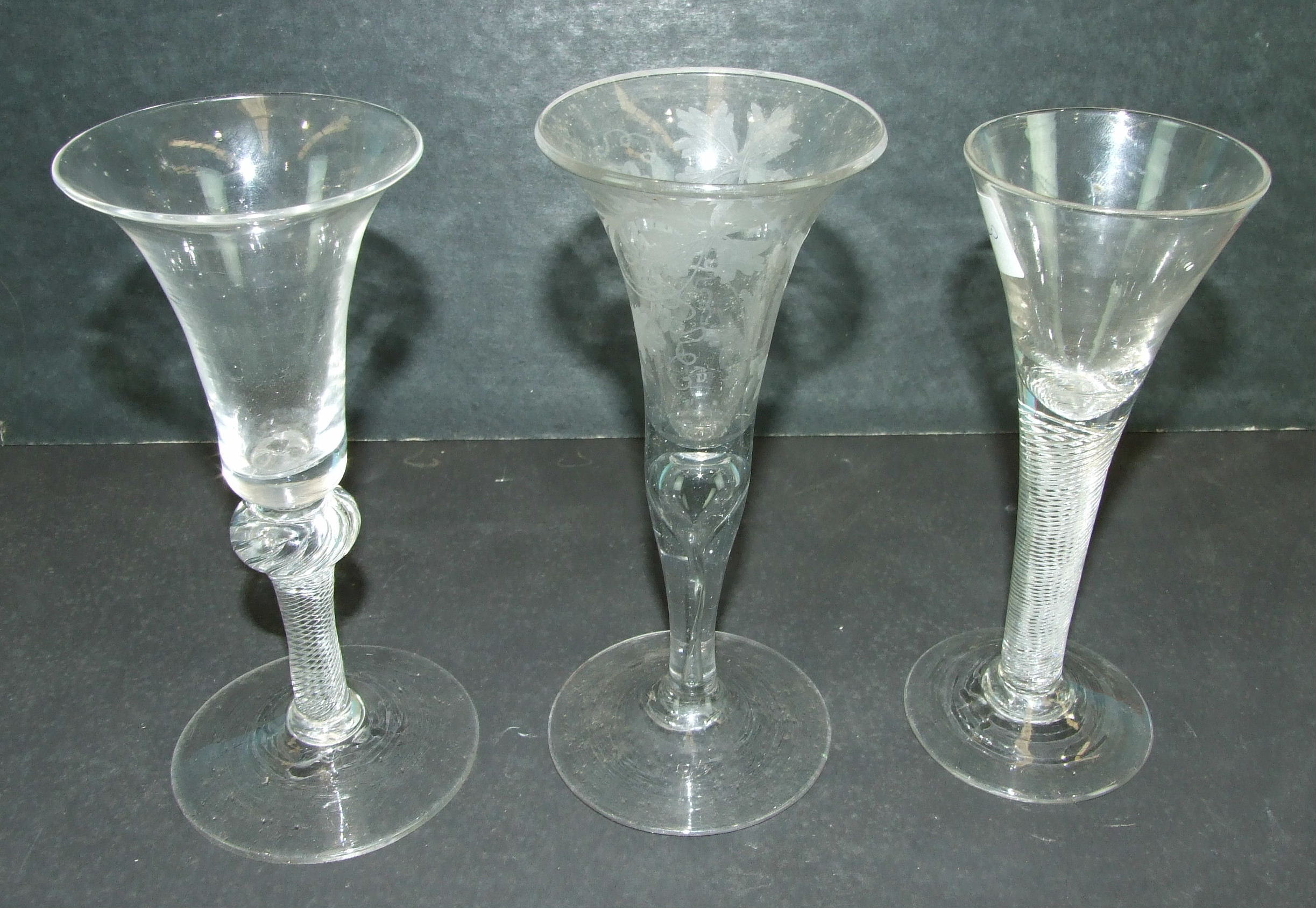 An 18th century English wine glass with trumpet bowl, on an air-twist stem, another with a knopped