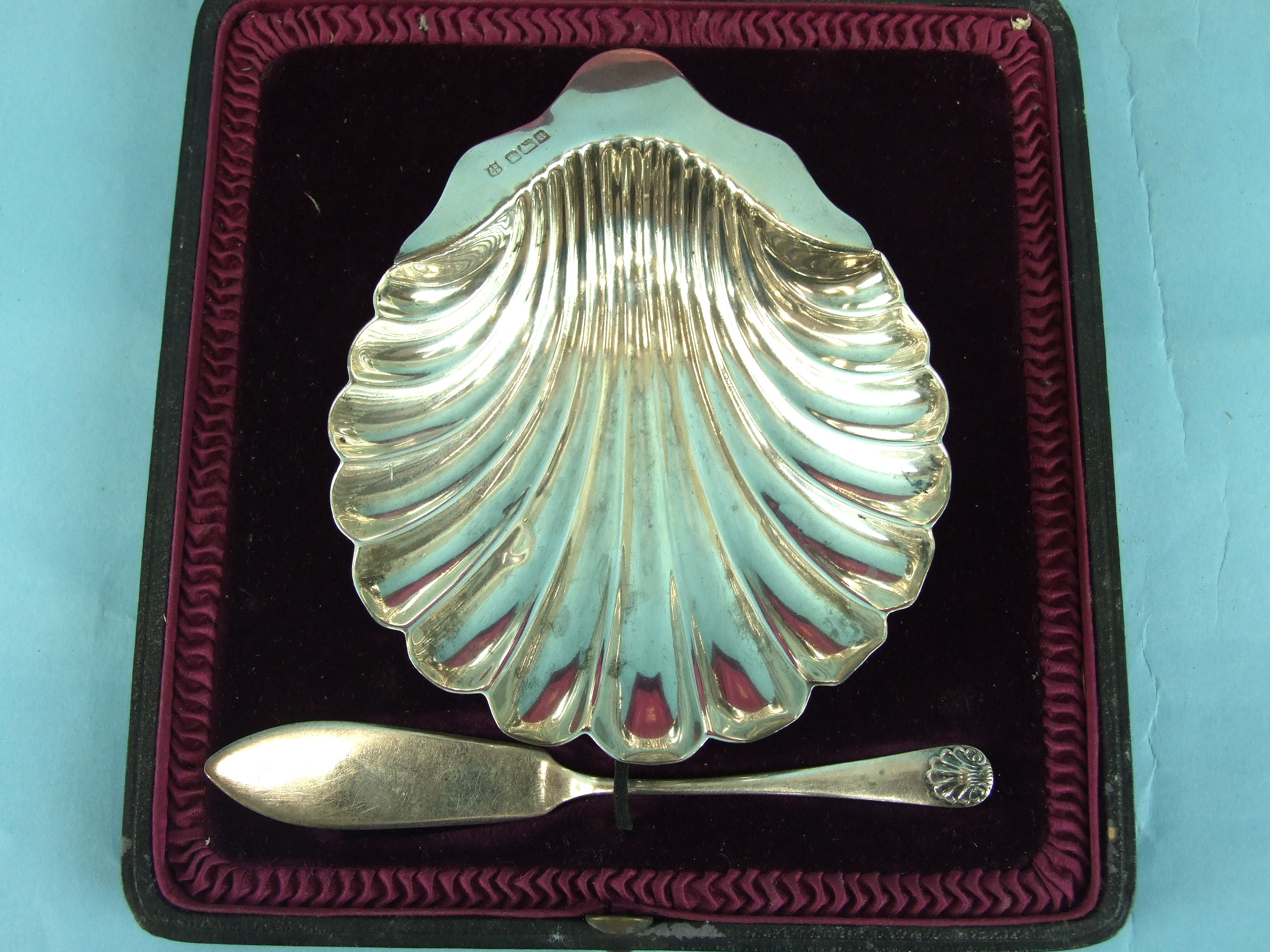 A shell-shaped butter dish and spoon in fitted box, maker James Deakin & Sons, Sheffield 1905,