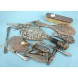 A collection of damaged silver-backed dressing table items, a walking cane top and other items.