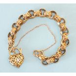 A 9ct gold bracelet of round links, each pierced with a scroll and leaf design, with heart-shaped