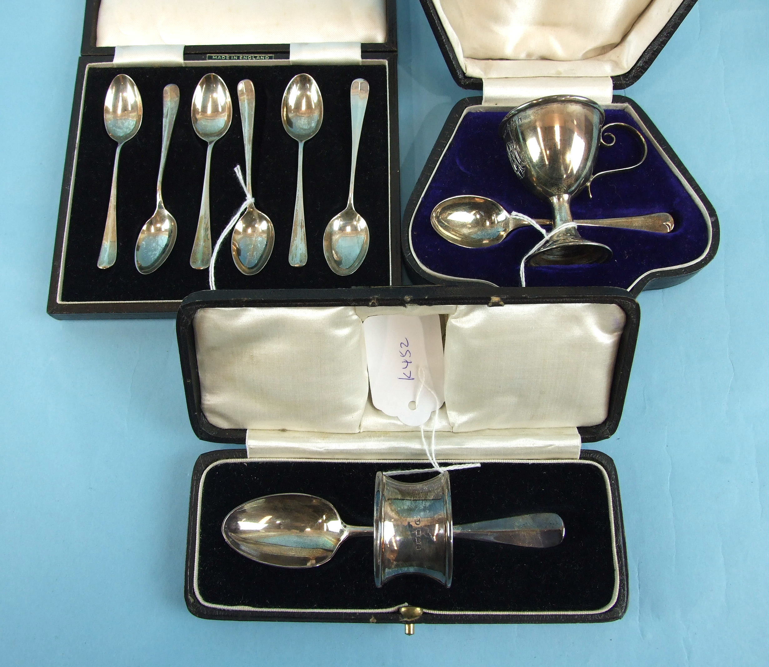 An egg cup and spoon in fitted box, Birmingham 1909, a napkin ring and spoon in case, London 1927