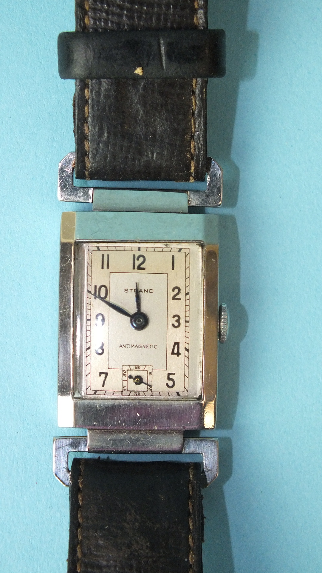 A gent's Strand mechanical wrist watch, the two-tone rectangular dial with Arabic numerals, in steel