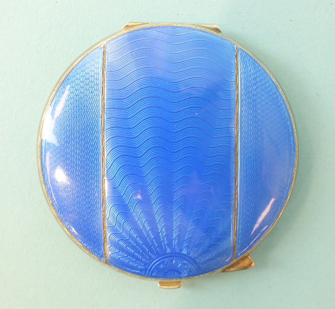 A circular silver powder compact, the blue guilloche lid enamelled in three panels, maker Turner &