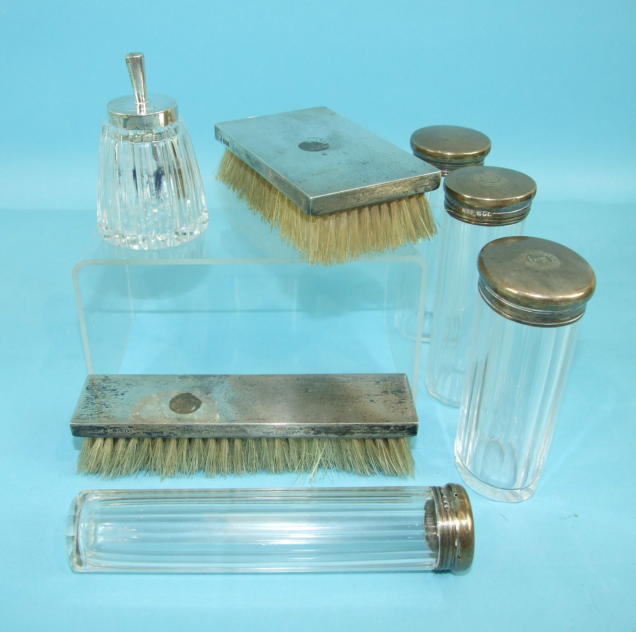 Four cut-glass dressing case bottles with silver mounts dated 1924, two silver-mounted hair