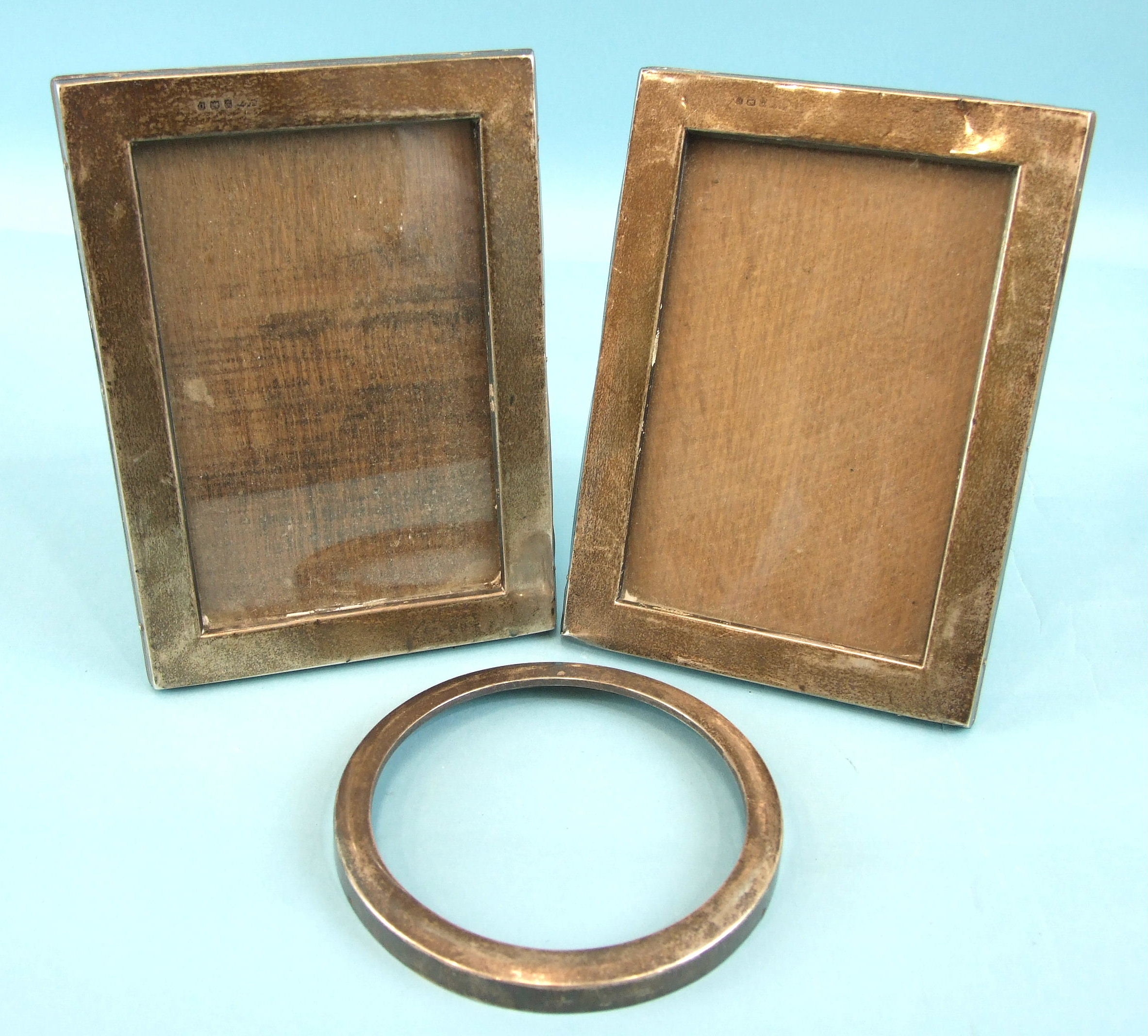 A pair of plain rectangular photo frames, Birmingham 1938, 17 x 12.5cm and a circular photo frame,
