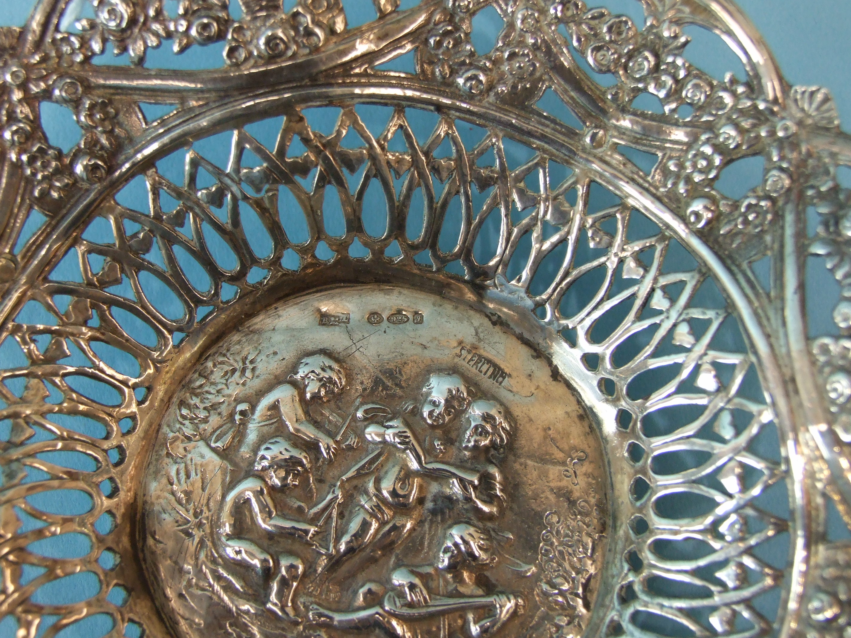 A Continental pierced circular dish, the centre embossed with putti playing musical instruments - Image 2 of 3