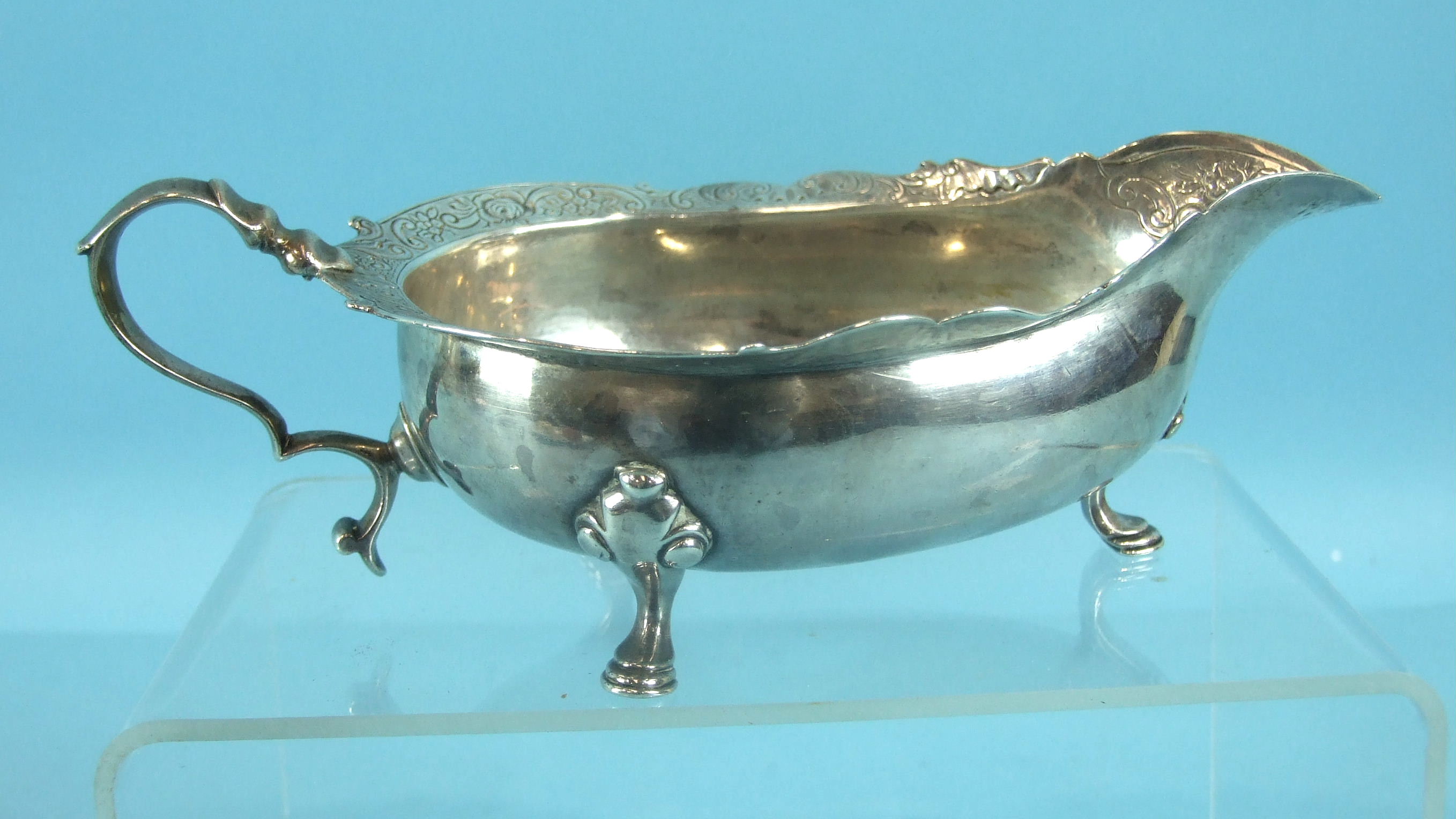 A George II Scottish cream or sauce boat on three hoof feet, with a shaped and chased rim and scroll - Image 2 of 3