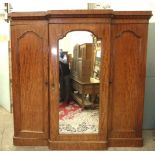 A Victorian mahogany breakfront wardrobe, the central mirror door enclosing maple drawers and