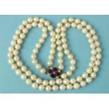 A necklace of two strings of uniform cultured pearls to 9ct gold amethyst and pearl cluster clasp.