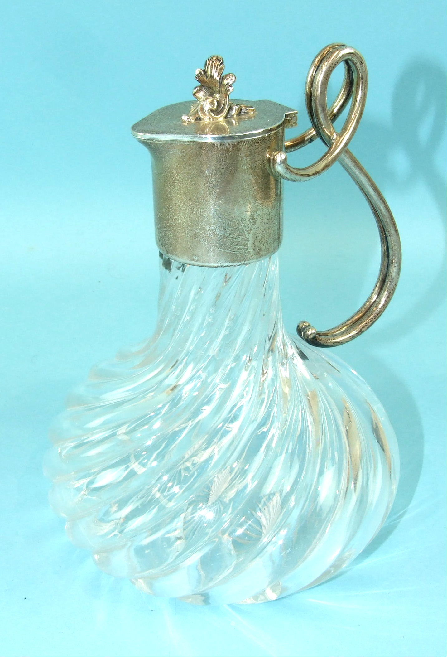 A Fabergé Russian silver-mounted glass jug, the hinged lid with cast foliate finial and double-